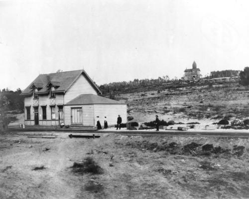 737: First Del Mar Train Station, built in 1886. This Santa Fe RR Depot occupied the area which is now the parking lot of the Del Mar Shores school at 9th Street and Stratford Court. In the distance is the Soledad School, built in 1885 overlooking Del Mar. It was called the Soledad School until 1903.

